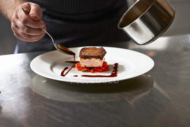 Salmon fillet and gravy being arranged — Stock Photo
