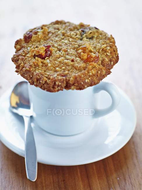 Raisin cookie on top of white cup — Stock Photo