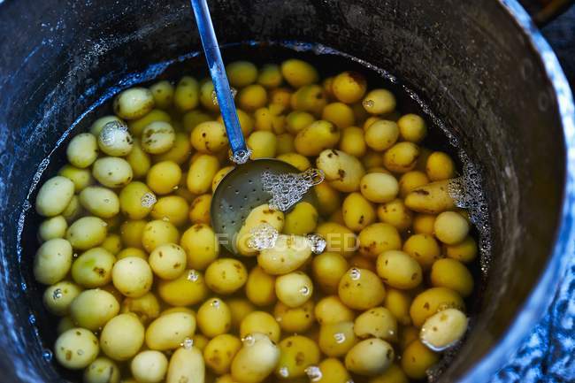 Batatas cruas em pote de água — Fotografia de Stock