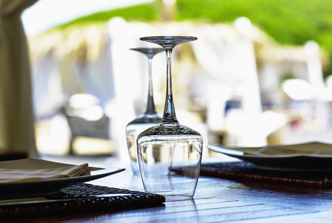 A place setting with upside-down wine glasses on a table in a restaurant — Stock Photo
