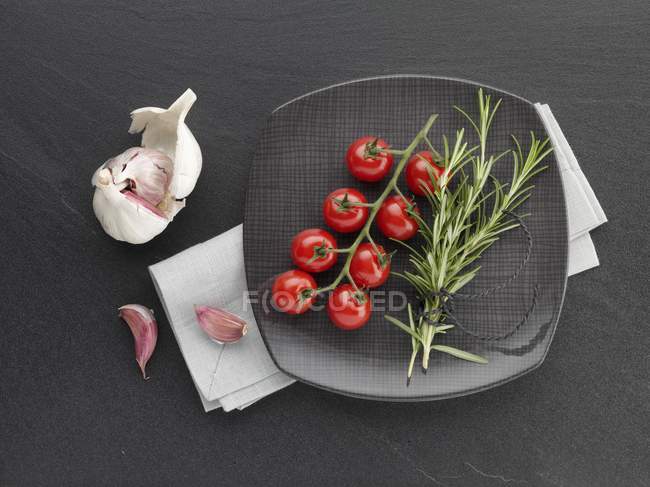 Tomatoes with rosemary and garlic — Stock Photo