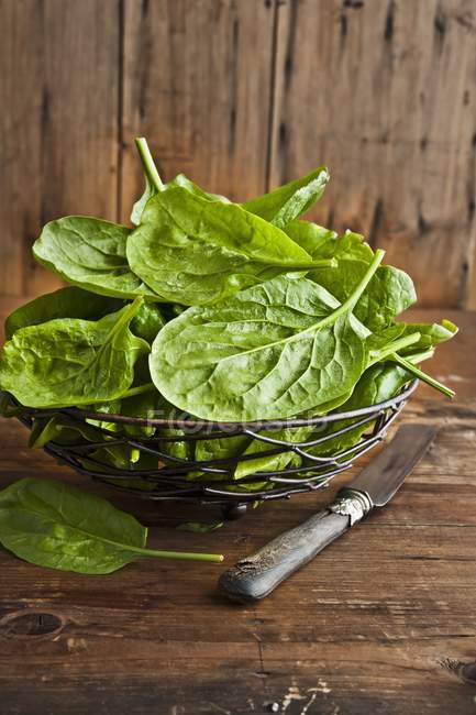 Fresh spinach in metal basket — Stock Photo