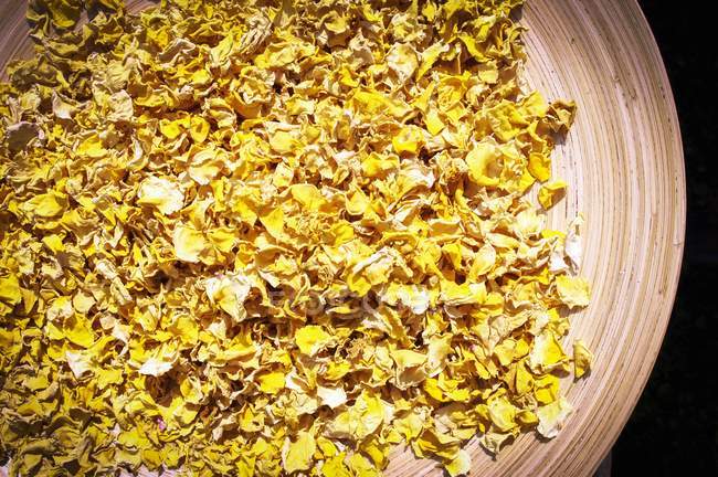 Top view of dried yellow rose petals in a bowl — Stock Photo