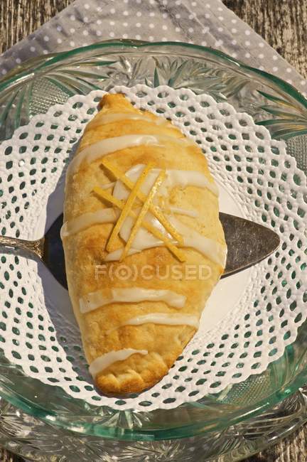 Closeup view of potato pastry parcel filled with apples and topped with icing sugar — Stock Photo