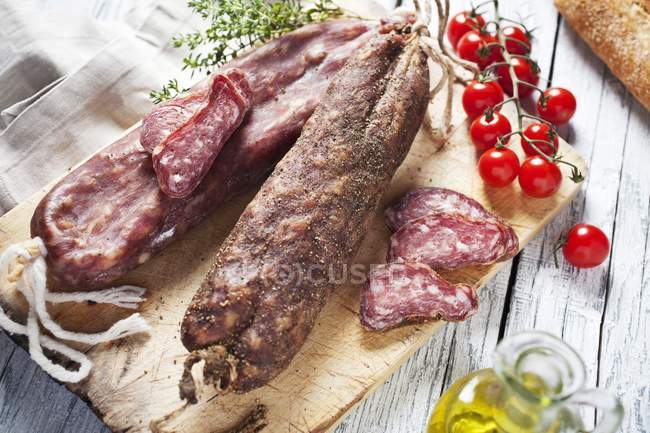Saucisses fumées espagnoles sur planche de bois — Photo de stock