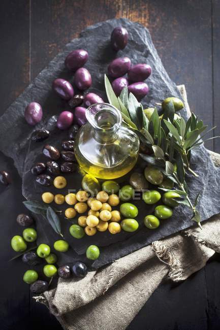 Jarra de aceite de oliva y aceitunas - foto de stock