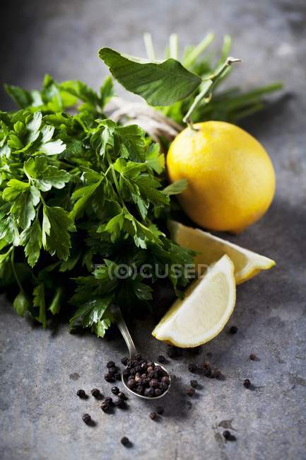 Lemons with parsley and peppercorns — Stock Photo