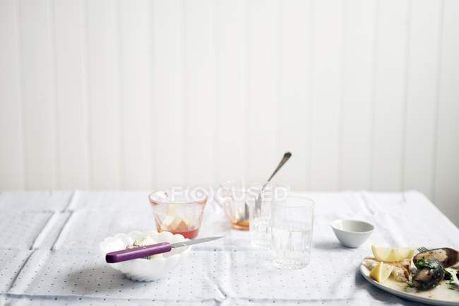 Gebrauchte Gläser und ein Teller mit Essensresten auf einem Tisch — Stockfoto