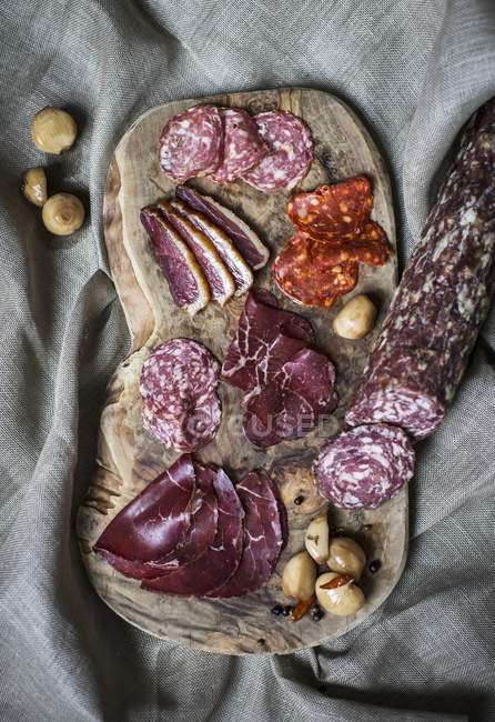 Tagliere con carne di manzo e salame essiccati all'aria dei Grigioni — Foto stock