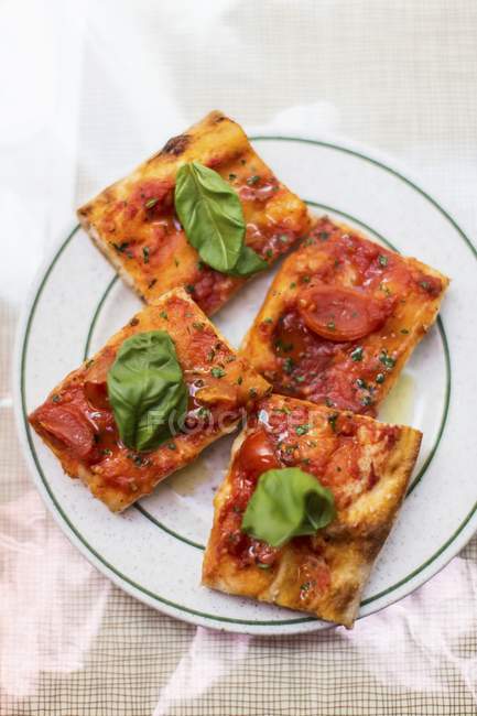 Rebanadas de pizza con tomates y albahaca - foto de stock