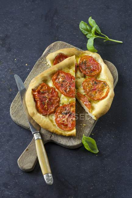 Vue du dessus de Tomate Focaccia sur planche à découper avec couteau — Photo de stock
