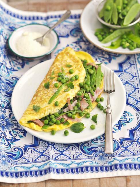 Omelette con piselli su piatto — Foto stock