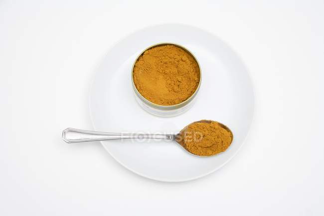 Madras curry powder in tin and on spoon — Stock Photo