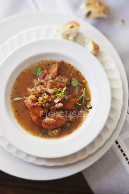 Літній бобовий суп з сосискою на білій тарілці — стокове фото