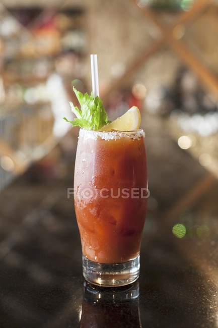 Closeup view of Bloody Mary cocktail with lemon, herb and straw in glass — Stock Photo