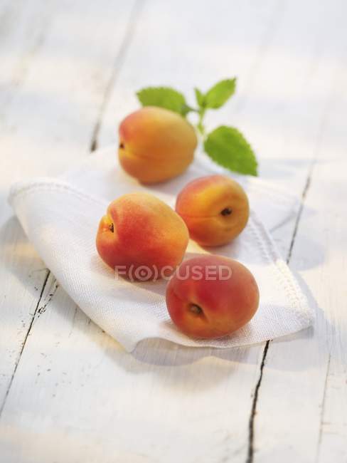 Vineyard peaches with leaves on fabric — Stock Photo