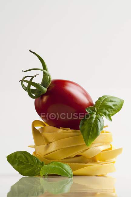 Tomato on tagliatelle pasta nest — Stock Photo