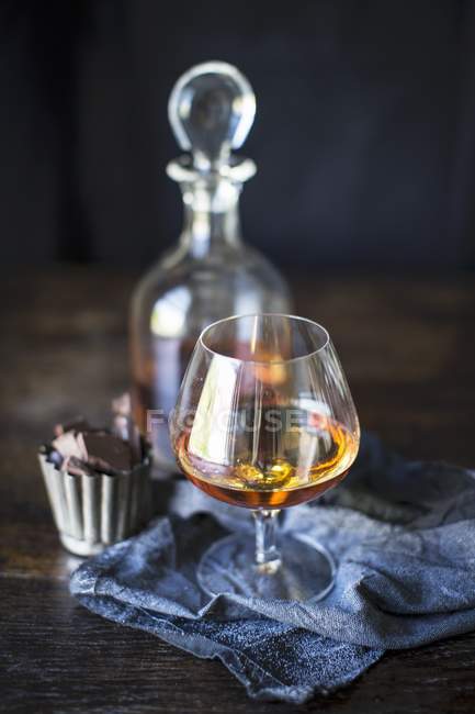Brandy im Glas mit Pralinen — Stockfoto