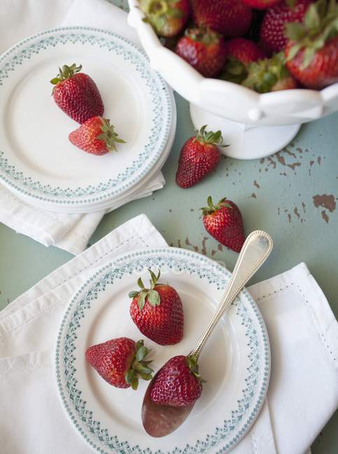 Strawberries with stalks om plates — Stock Photo