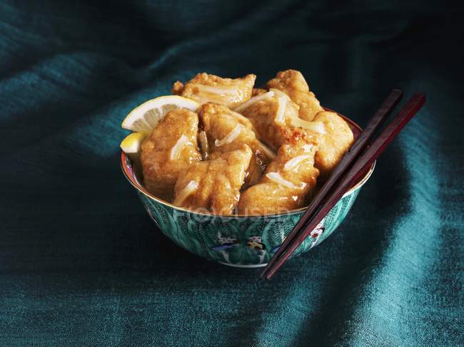 Primo piano vista di pollo al limone cinese in una ciotola con le bacchette — Foto stock
