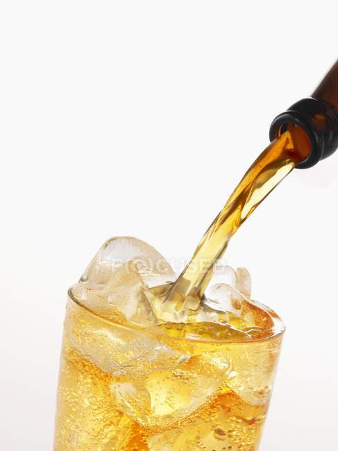 Closeup view of pouring apple cider to glass with ice cubes — Stock Photo