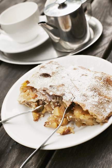 Apple strudel on white plate with forks — Stock Photo