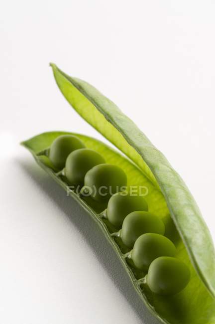 Fresh peas in opened pod — Stock Photo