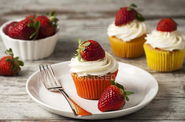Strawberry cupcakes topped with cream — Stock Photo