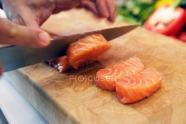 Raw salmon being sliced — Stock Photo