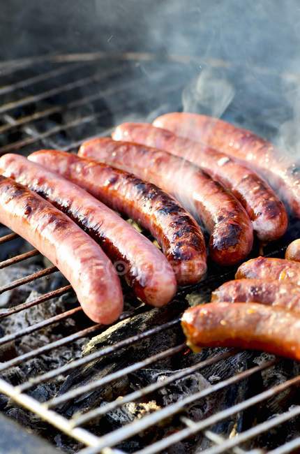 Chipolata sausages on barbecue — Stock Photo
