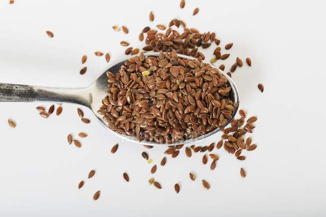 Spoonful of organic flax seeds — Stock Photo