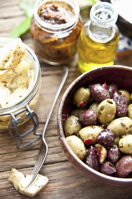 Italian antipasti: marinated olives, artichoke hearts and dried tomatoes — Stock Photo