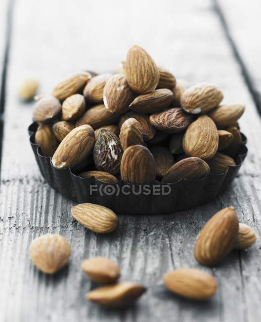 Brown almonds in dish — Stock Photo