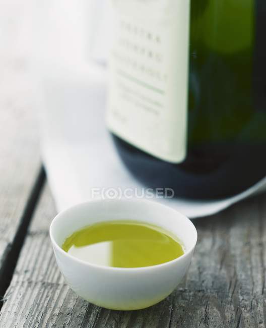 Closeup view of olive oil in a white porcelain bowl — Stock Photo