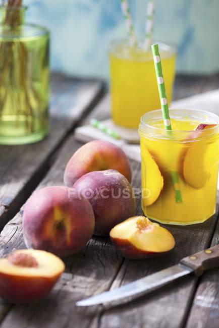 Peach juice and peaches — Stock Photo