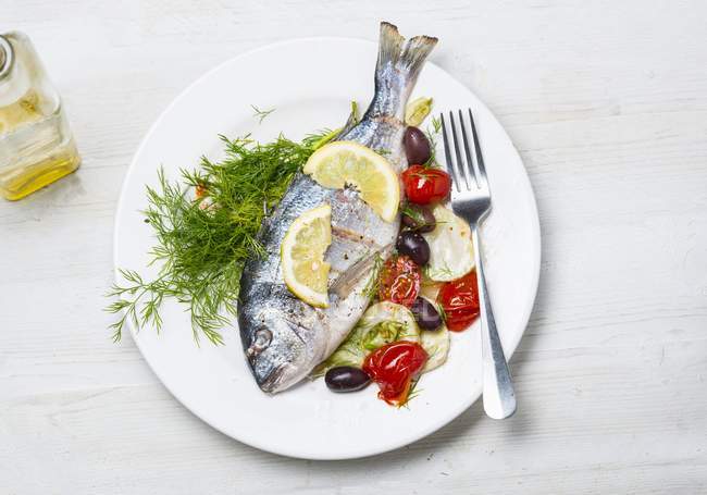 Baked sea bream with tomatoes and olives — Stock Photo