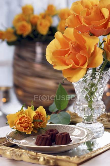 Pralinen und orange Rosen — Stockfoto