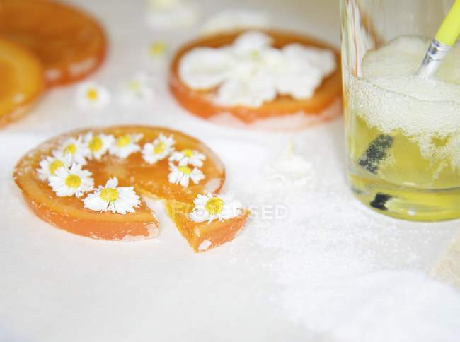Вид крупным планом консервированных апельсиновых ломтиков, украшенных маргаритками — стоковое фото