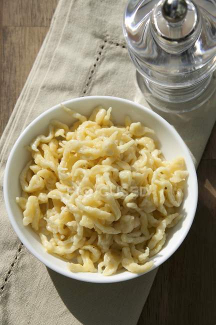 Closeup top view of butter Sptzle noodles in a white porcelain bowl — Stock Photo