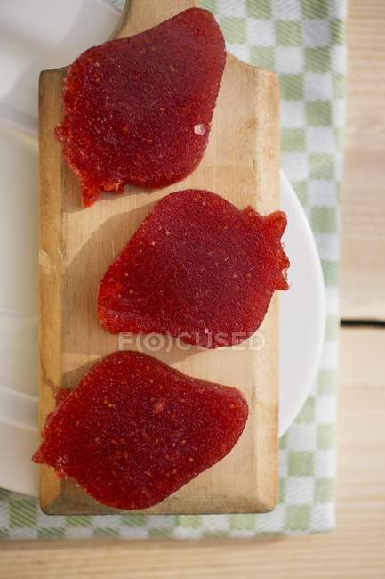 Closeup top view of strawberry-shaped strawberry jellies on wooden board — Stock Photo