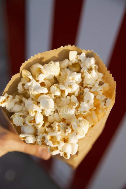 Paper bag full of popcorn — Stock Photo