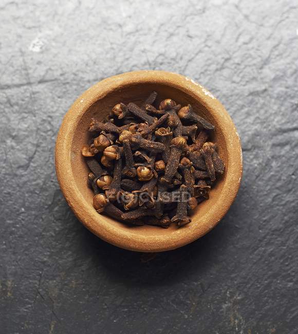 Rustic bowl of cloves — Stock Photo