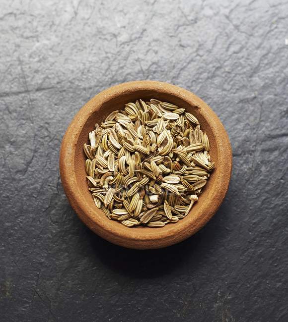Una ciotola di semi di finocchio sulla superficie di legno — Foto stock