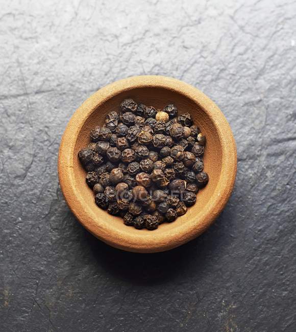 Bowl of black peppercorns — Stock Photo