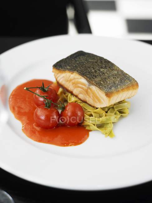 Filete de salmón sobre pasta de tagliatelle verde - foto de stock