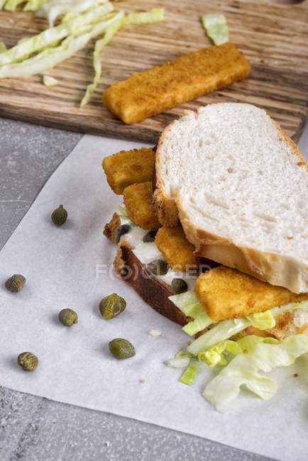 Sandwich aux doigts de poisson avec sauce — Photo de stock