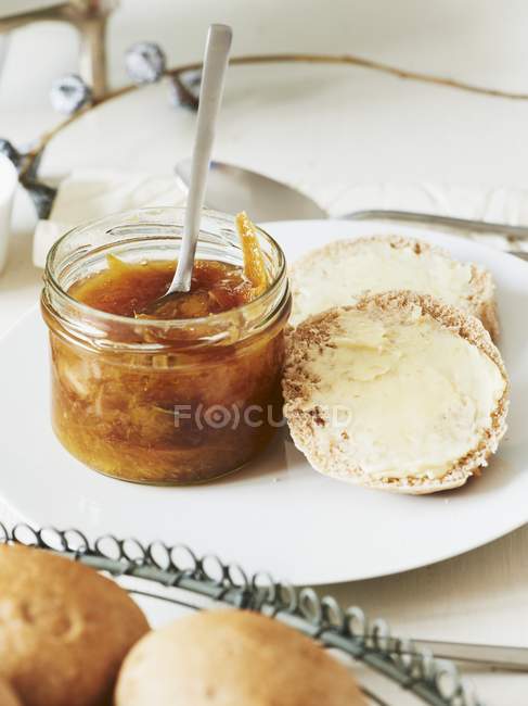 Closeup view of orange marmalade and bread slices — Stock Photo