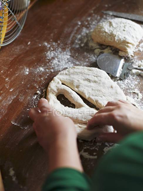 Cropped elevated view of hands making Fougasse with raw dough — Stock Photo