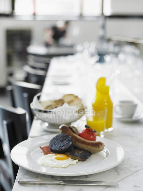 Desayuno inglés con tostadas, salchichas, tomate y huevo frito - foto de stock