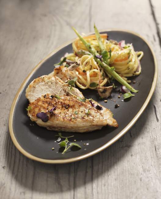 Chicken breast with noodle salad — Stock Photo